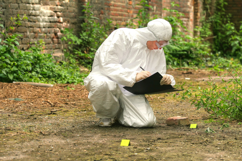 person in hazmat suit examining a crime scene